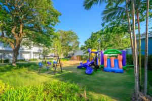 a playground in a yard with palm trees at Centara Karon Villas Phuket in Karon Beach