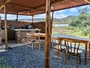 a patio with a table and chairs under a roof at Glamping Entre Nopales - Sáchica cerca a Villa de Leyva in Sáchica