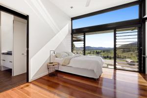 a bedroom with a bed and a large window at Riverdance At Conondale in Conondale