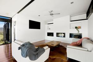 a living room with white furniture and a fireplace at Riverdance At Conondale in Conondale