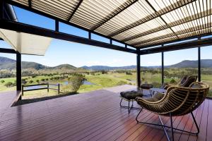 a deck with chairs and a view of the mountains at Riverdance At Conondale in Conondale