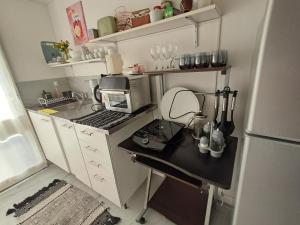 a small kitchen with a sink and a microwave at C&MHouse in Buenos Aires