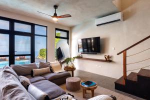 a living room with a couch and a tv at Villa Odyssea BVI in Tortola Island