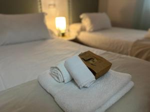 a pile of towels on top of a bed at Casa Centro Fuengirola Gran Patio in Fuengirola