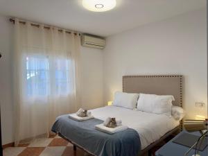 a bedroom with a bed with two stuffed animals on towels at Casa Centro Fuengirola Gran Patio in Fuengirola