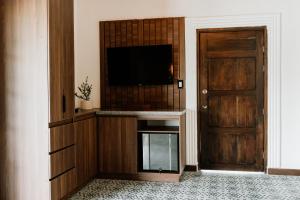 a living room with a television and a door at Hotel Catleya Royal Club in Pereira