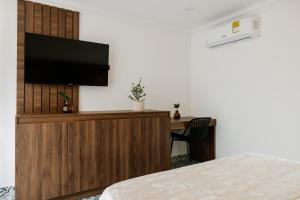 a bedroom with a bed and a television on a wall at Hotel Catleya Royal Club in Pereira