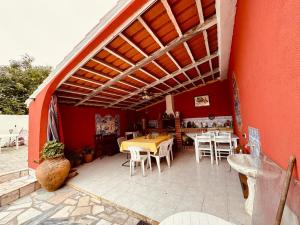 a patio with tables and chairs in a red building at Casa Alma Serena in Batalha