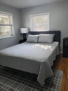 a large bed in a bedroom with two windows at The Sky Lounge-Brunswick in Brunswick