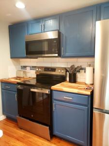 a kitchen with blue cabinets and a black stove top oven at The Sky Lounge-Brunswick in Brunswick +19 photos