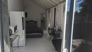 a room with a balcony with a bed and a refrigerator at Casa proximo ao aeroporto in Florianópolis