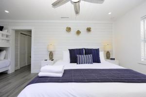 a white bedroom with a large bed with blue pillows at Siesta Key Beach Resort and Suites in Sarasota