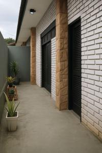a hallway of a house with two black garage doors at Suítes Praia dos Sonhos in Itanhaém