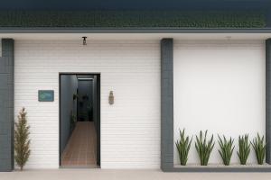 a white brick house with a black door at Suítes Praia dos Sonhos in Itanhaém +5 photos