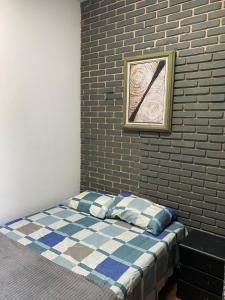 a bed in a room with a brick wall at Suítes Praia dos Sonhos in Itanhaém