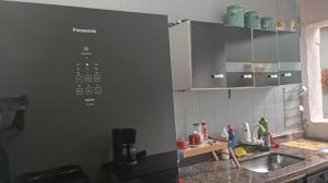 a kitchen with a sink and a counter at Suítes Praia dos Sonhos in Itanhaém
