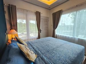 a bedroom with a blue bed and a window at Arkana Huis in Perawas