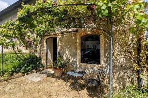 a patio with a table and chairs next to a building at L'Ecurie Former stable with charm and light in Ingrandes