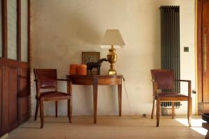 a table with two chairs and a lamp on it at L'Ecurie Former stable with charm and light in Ingrandes