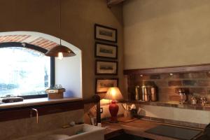 a kitchen with a sink and a window and a lamp at L'Ecurie Former stable with charm and light in Ingrandes