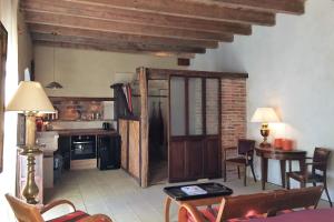 a living room with a table and a kitchen at L'Ecurie Former stable with charm and light in Ingrandes