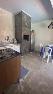 a kitchen with a refrigerator and a table with chairs at Apartamento 03 - Refúgio do Descanso in São Francisco do Sul