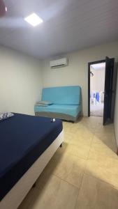 a bedroom with a blue bed and a room with a door at Apartamento 03 - Refúgio do Descanso in São Francisco do Sul