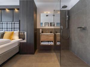 a bathroom with a shower and a bed and a sink at Alpenchalet Lambert in Sankt Lambrecht +63 photos