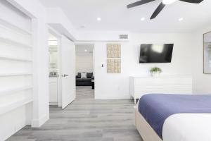 a white bedroom with a bed and a ceiling fan at Siesta Key Beach Resort and Suites in Sarasota