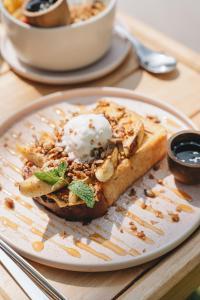 a plate with a piece of bread with ice cream on it at Meraki in Polhena