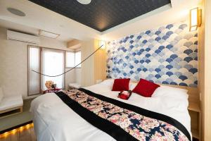 a bedroom with a large bed with red pillows at Hotel Opera in Tokyo