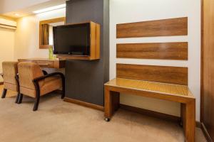 伊瓜蘇港的住宿－埃克斯卡塔拉塔斯酒店，客房设有书桌、电视、桌子和椅子。