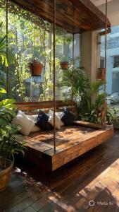 a large wooden bench in a room with plants at Lamera Homestay & Coffee in Ben Tre