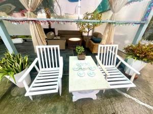 two white chairs and a table with plates on it at Lamera Homestay & Coffee in Ben Tre
