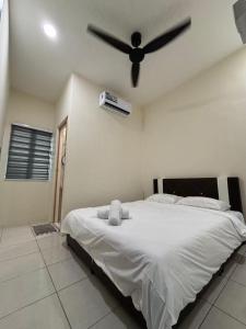 a bedroom with a bed with a ceiling fan at EcoPutra Stay in Ipoh +35 photos