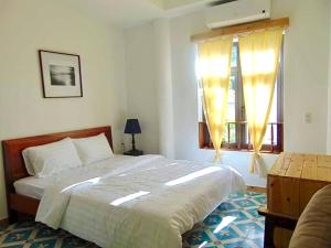 a bedroom with a large bed and a window at LaMera Homestay in Ben Tre +9 photos