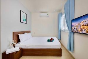 a bedroom with a bed and a flat screen tv at LaMera Homestay in Ben Tre
