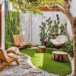 a garden with a swing and logs and grass at LaMera Homestay in Ben Tre