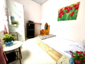 a small room with a table and a refrigerator at LaMera Homestay in Ben Tre
