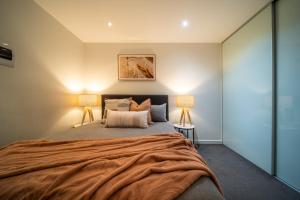 a bedroom with a large bed with two lamps at Infinity on Morphett - Stay Central in the CBD in Adelaide +34 photos