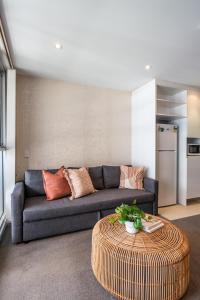a living room with a couch and a table at Infinity on Morphett - Stay Central in the CBD in Adelaide