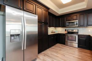 a kitchen with stainless steel refrigerator and wooden cabinets at Phoenix Gulf Shores 903 in Gulf Shores