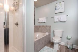 a bathroom with a toilet and a bath tub at Phoenix Gulf Shores 903 in Gulf Shores