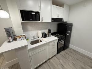 a small kitchen with a sink and a stove at Renovated Beachfront Studio, New Kitchen, Pool in Daytona Beach