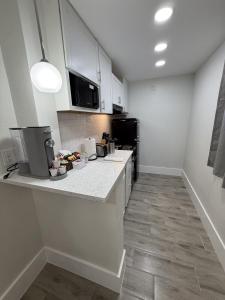 a kitchen with white cabinets and a counter top at Renovated Beachfront Studio, New Kitchen, Pool in Daytona Beach
