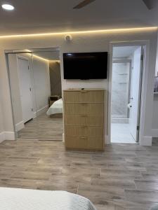 a bedroom with a flat screen tv and a mirror at Renovated Beachfront Studio, New Kitchen, Pool in Daytona Beach +12 photos