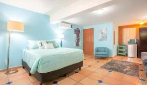 a bedroom with a bed and a blue wall at Great cozy place near Malecón in La Paz