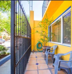 a balcony with two chairs and a yellow wall at Great cozy place near Malecón in La Paz