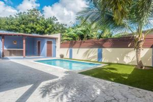 a swimming pool in a yard next to a house at Luce del sole in Oranjestad