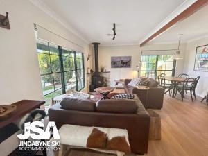 a living room with a couch and a table at Lakeside Chalet in Jindabyne